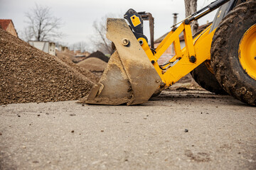 A bulldozer is working with gravel on construction site.
