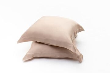 Two pillows in beige pillow cases on white background