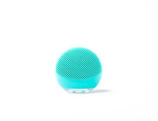 Mint colored facial cleansing brush isolated on white background. Cosmetic accessory. Beauty concept.