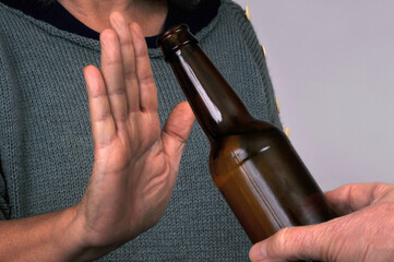 Quelqu'un refusant une bouteille d'alcool avec la main