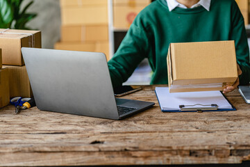 Businesswoman starting a small business SME success Freelance woman working from home with laptop online shopping with online parcel delivery. SME concept and package delivery.