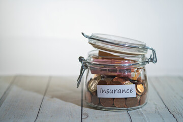 a jar full of coins and banknotes with a label that says insurance
