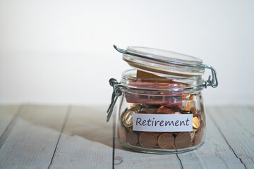 a jar full of coins and banknotes with a label that says retirement
