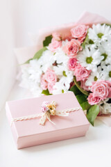 Obraz na płótnie Canvas Beautiful bouquet of rose and chrysanthemums flowers and pink gift box on white table background. Gift for holiday, birthday, Wedding, Mother's Day, Valentine's day, Women's Day. Floral arrangement.