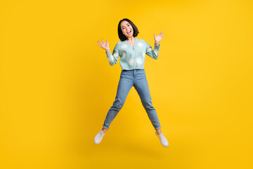 Fototapeta na wymiar Full size photo of cheerful good mood woman bob hairstyle dressed blue pullover flying having fun isolated on yellow color background