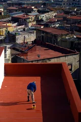Sierkussen old man paints the roof of the house in the city of Naples Italy © reznik_val