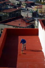 Gordijnen old man paints the roof of the house in the city of Naples Italy © reznik_val