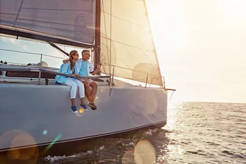 Fototapeten Holiday, relax and couple on a yacht in the ocean for adventure, freedom and sailing trip. Travel, summer and mature man and woman on a boat in the sea for a romantic seaside vacation in Greece. © Reese/peopleimages.com