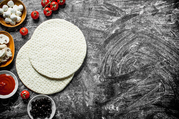 Raw pizza. The dough with the ingredients for making pizza.