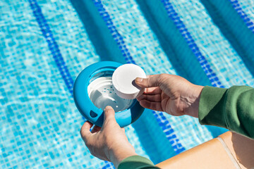 Pool water maintenance with the automatic chlorine tablet dispenser. pool cleaner with white...