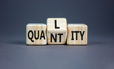 Quality and quantity symbol. Concept word Quality Quantity on wooden cubes. Beautiful grey table...