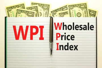 WPI wholesale price index symbol. Concept words WPI wholesale price index on white note on a beautiful background from dollar bills. Business WPI wholesale price index concept. Copy space.