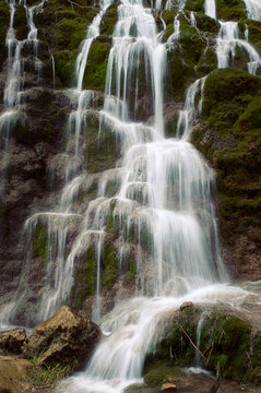 Beautiful front photograph of a wonderful waterfall that runs between mossy rocks