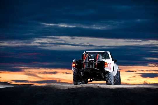 A baja style rally truck drives through the sand at Knolls Recreation Area, UT - Powered by Adobe
