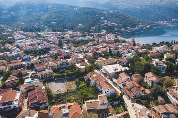 Naklejka na ściany i meble Aerial drone view of Kassiopi, village in northeast coast of Corfu island, Ionian Islands, Kerkyra, Greece in a summer sunny day, with marina, town, beach and castle