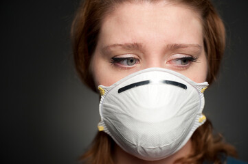 Studio portrait of 24 year old caucasian female wearing a N95 mask.