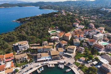 Fototapeta na wymiar Aerial drone view of Kassiopi, village in northeast coast of Corfu island, Ionian Islands, Kerkyra, Greece in a summer sunny day, with marina, town, beach and castle
