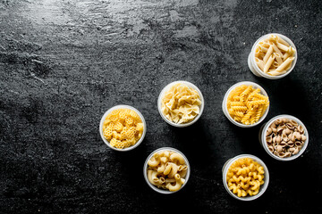 Variety of dry pasta in bowls.