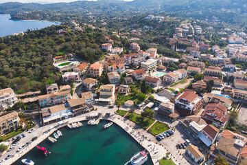 Fototapeta premium Aerial drone view of Kassiopi, village in northeast coast of Corfu island, Ionian Islands, Kerkyra, Greece in a summer sunny day, with marina, town, beach and castle