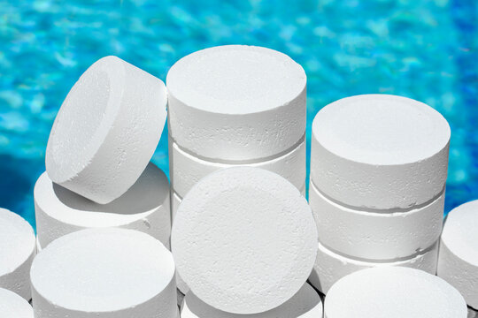 chlorine for swimming pool. Close-up white chlorine tablets for cleaning and disinfecting pool water. chlorine pill to balance the ph of the pool inside an automatic dispenser.