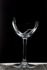 Broken glass goblet. Stands on black boards. Shot on a black background.