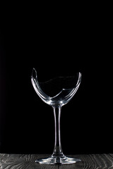 Broken glass goblet. Stands on black boards. Shot on a black background.
