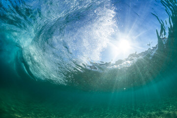 Fototapeta na wymiar dramatic underwater scene with a crashing wave in crystal clear water