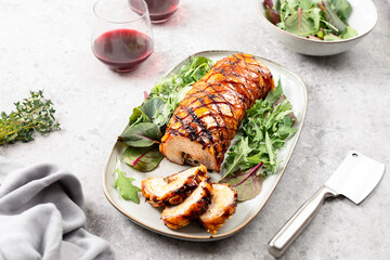 Homemade baked porchetta in rolls with several herbs, pepper and garlic