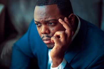 Black or African American business man sitting down looking anxious and depressed