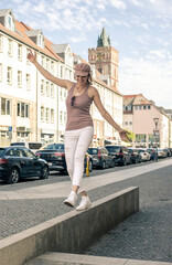 glückliche junge Frau balanciert  in der Stadt - obrazy, fototapety, plakaty