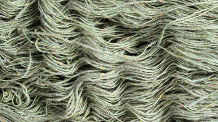 Threads of natural organic sheep wool. Unwound skein of olive green knitting yarn.