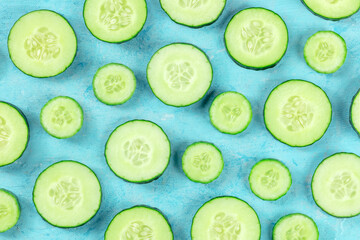 Fresh cucumber slices on a blue background, overhead flat lay shot. Healthy organic food design