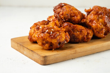 Pieces of deep-fried chicken in Asian style close-up lies on a wooden board.