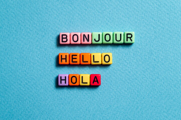 Bonjour hello hola - word concept on cubes