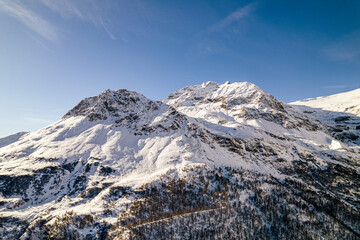 Fototapeta na wymiar Mountain peak with rocks covered in snow during winter on a sunny day in Switzerland.