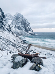 Beach and ocean surrounded by mountains during winter in Kvalvika Beach, Lofoten, Norway.