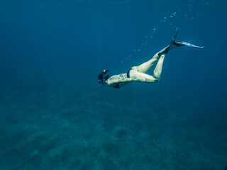 Obraz na płótnie Canvas Young white caucasian woman snorkeling underwater.