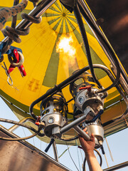 Hand of a man adding hot air to the inside of a balloon.