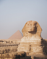 The Sphynx with a pyramid in the background in Giza, Cairo, Egypt.