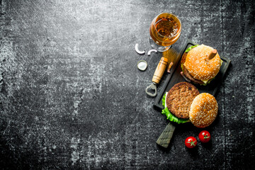 Burgers with a knife and beer in a glass.