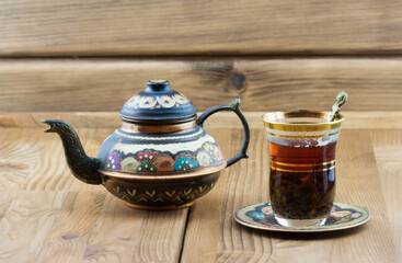 Traditional Turkish tea set: vintage glass cup with teapot on wooden table