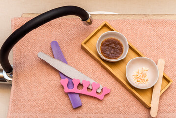 objects, files and creams on a light towel and a faucet for making pedicures