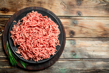 Raw minced meat in a plate with spices and herbs .