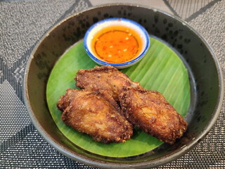 Batter fried chicken wings served with sweet dipping sauce in black cup lined with banana leaves cut in circular shape. Buffalo Wings marinated with seasoning Dip in crispy batter and fry in hot oil
