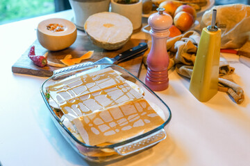 Cooking winter lasagna with fresh winter vegetables in home kitchen on marble kitchen top