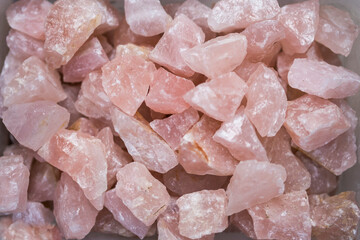 Pile of Raw Rose quartz stone textured surface background. Selective Focus Center Front.