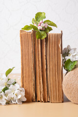 Blossom apple twigs with vintage books. Spring still life composition