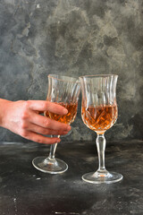 Close up photo of woman hand with a glass of liquor, black background.