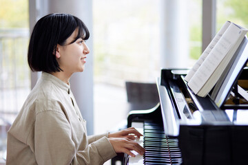 ピアノを演奏する若い日本人女性 © west_photo