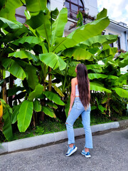 young woman long hair model behind palm trees - 562408049